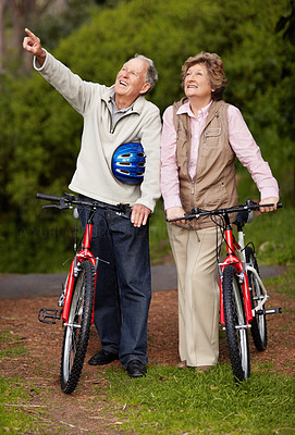 Mature couple with cycle, man pointing at something interesting