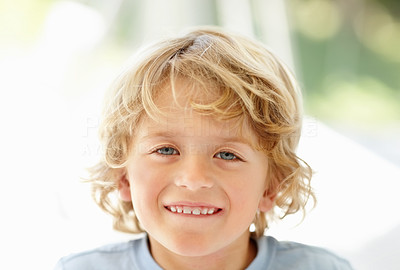 Happy innocent boy smiling against blur background