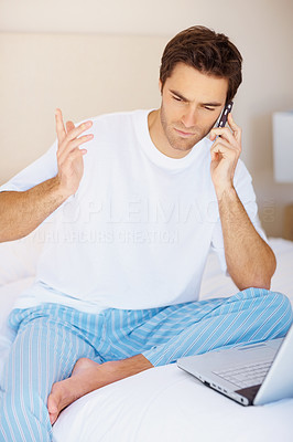 Young man in bed speaking on the cellphone