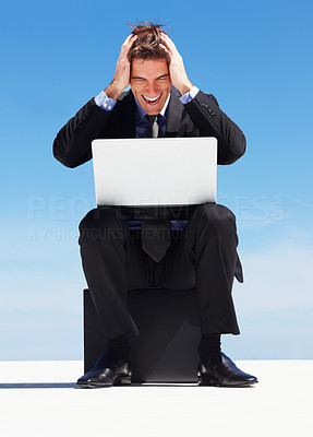 Excited young business man looking at laptop