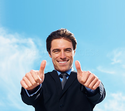 Smart business man with thumbs up with copyspace against sky