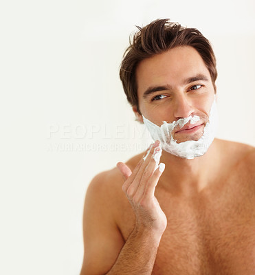 Young guy applying cream to his face for a shave