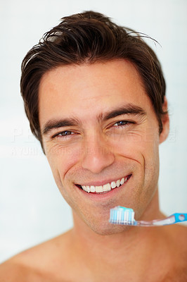 Closeup of a happy young man about to brush his teeth