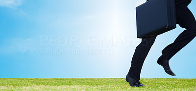 Business man running away with a briefcase on a field