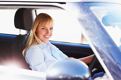Smiling female sitting in the driver\'s seat of a car