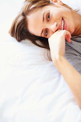 Top view of a woman lying with a smile in bed , copyspace
