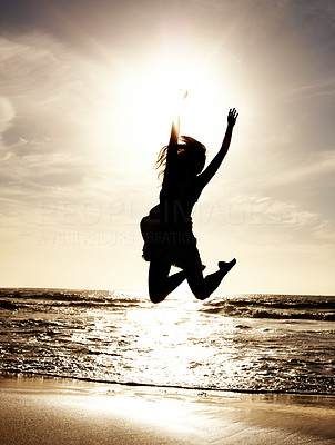 Happy young lady jumping on beach