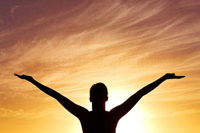 Silhouetted lady with arms out against beautiful sky at sunset