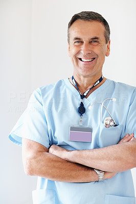 Confident medical doctor with hands folded against white