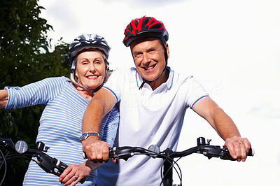 Smiling mature couple with bicycles on a sunny day
