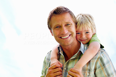 Smiling father carrying his son on back against white