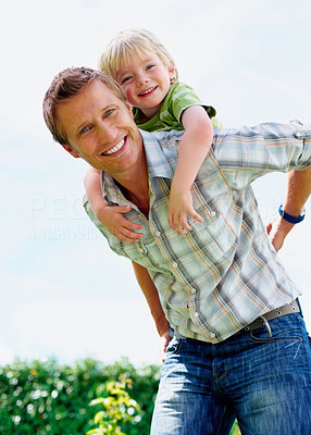 Smiling father giving his son piggyback ride