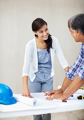 Young woman discussing home renovation plan with contractor