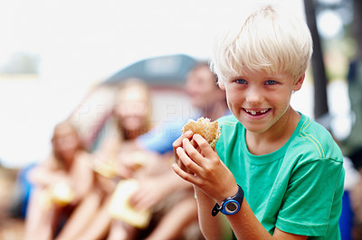 Young boy eating burger