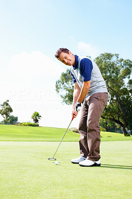 Smiling golfer putting the ball