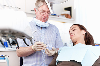 Dentist holding false teeth in clinic
