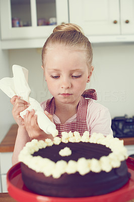 Carefully icing her first cake