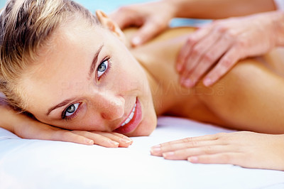 Happy young lady receiving shoulder massage at a health spa