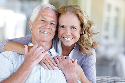 Portrait of smiling senior couple with the wife hugging her husband from behind with copyspace
