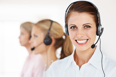 Pretty call center executive with colleagues in background