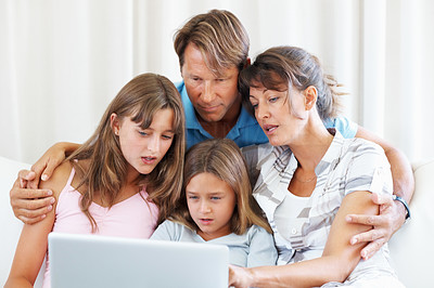Family of four using laptop