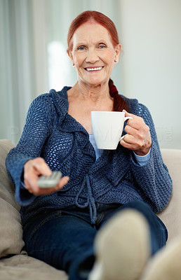 Woman holding a cup of tea or coffee while watching television