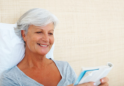 Senior woman reading a novel and smiling