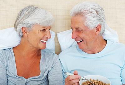 Senior couple smiling and looking at each other in bed