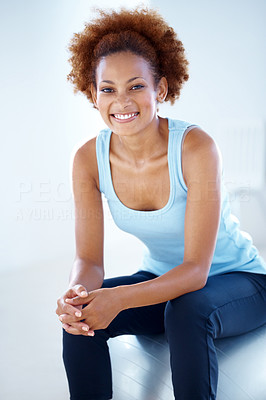 Happy female fitness instructor sitting on ball