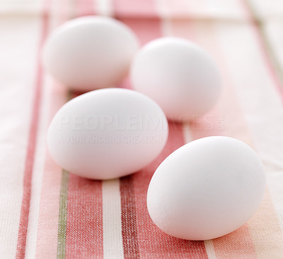 Four chicken white eggs on tablecloth