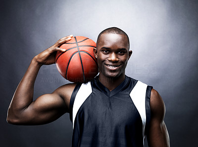 Smiling male basketball player against dark background