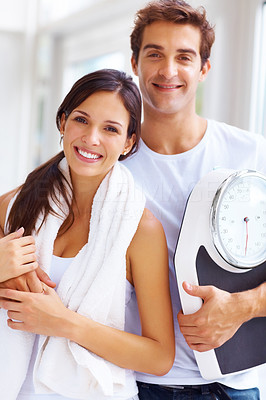 Healthy life - Young couple holding a weight scale