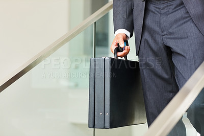 Business man carrying a cellphone and suitcase