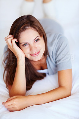 Happy Caucasian brunette female lying on the bed