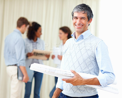 Smiling business man holding blueprint