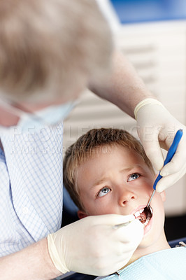 Doctor checking boy\'s teeth