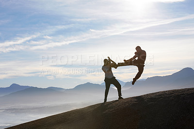 Two male kickboxers fighting on a mountain top