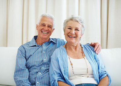 Happy old couple sitting together on sofa