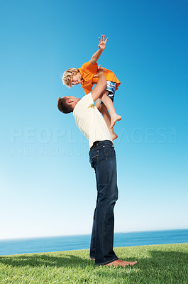 Little boy being lifted up by his father