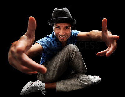 Happy young bboy pointing at you against black background
