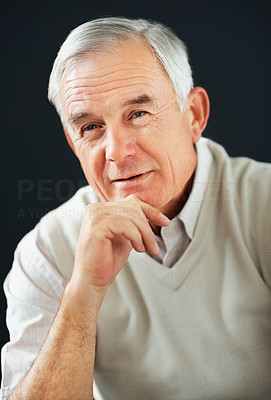 Smiling elderly man with hand on chin