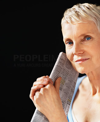 Portrait of a smiling senior female holding newspaper