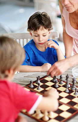 Little boy playing chess with his family - Indoors