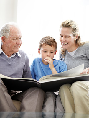 Happy family sitting together and reading a book - Indoor