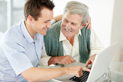 Happy man helping his father to learn computer