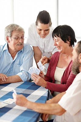 Senior people playing card game at home