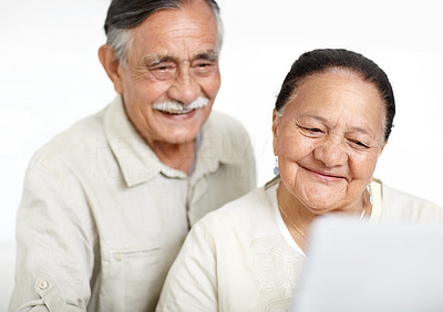 Closeup of a smiling old couple working on laptop