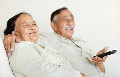 Happy old couple watching televison together