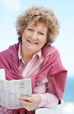 Happy old female reading a newspaper - Outdoor