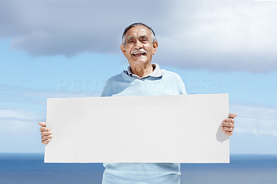 Smiling senior man holding a blank billboard